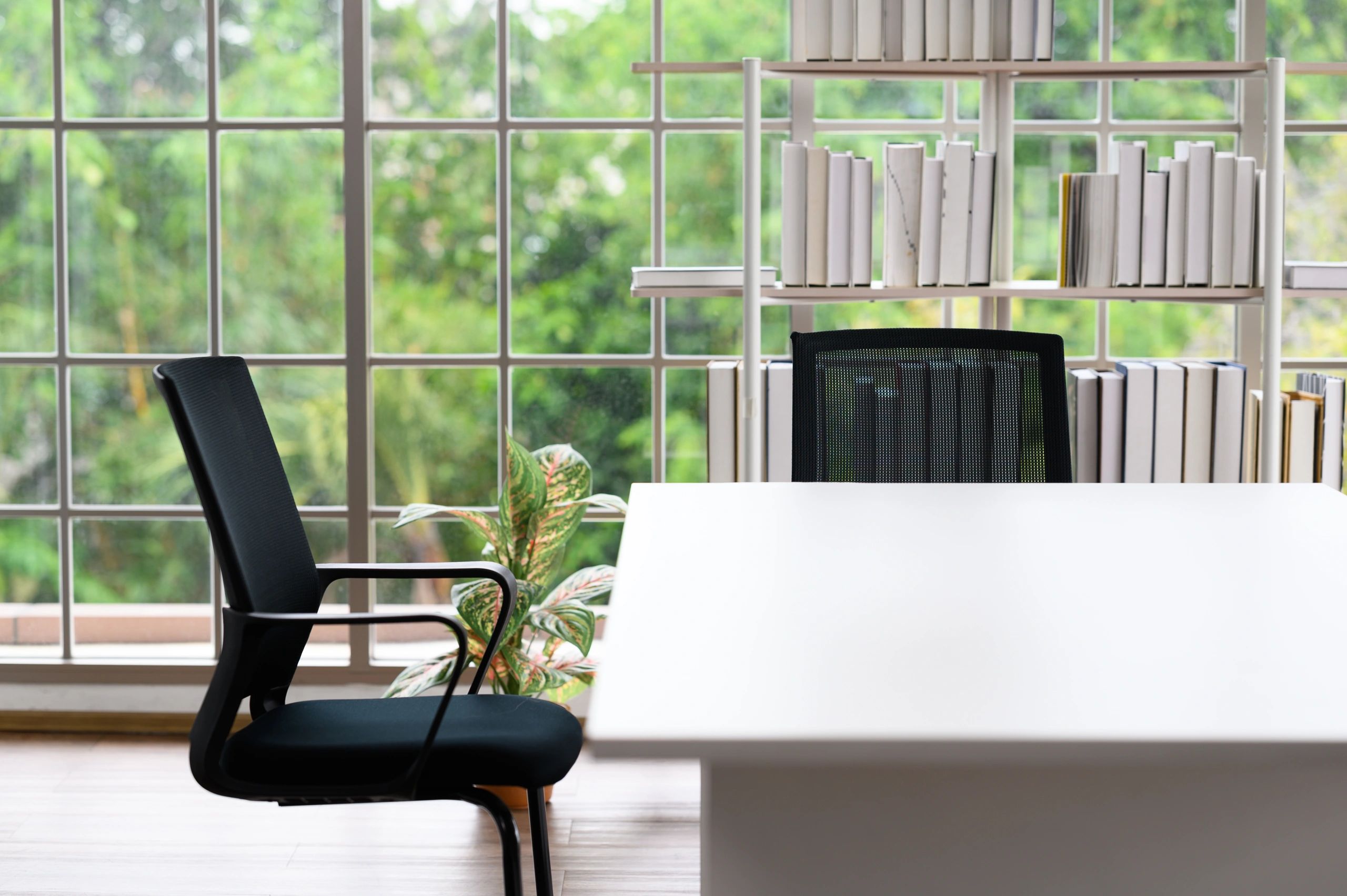 Desk with chair and bookshelf by a window